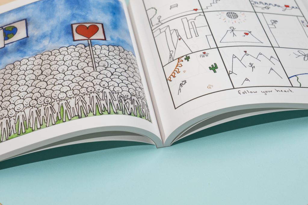 Perfect-bound comic printing; graphic novel opened flat with crisp gutters and sturdy square spine.