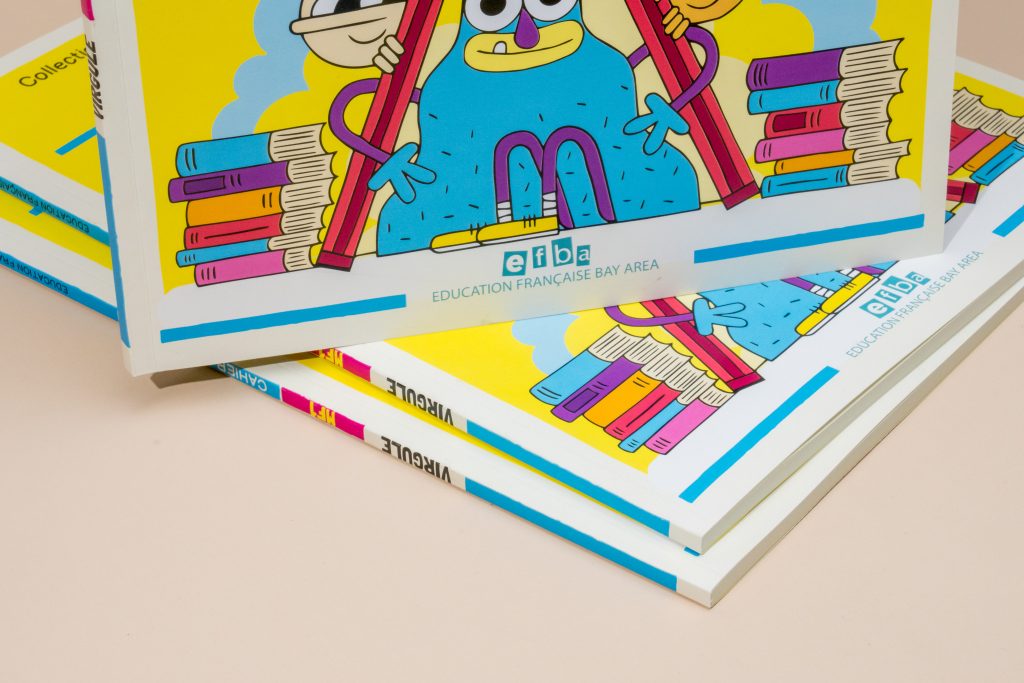 Stack of perfect-bound comics with bold illustrated covers printed by GreenerPrinter.
