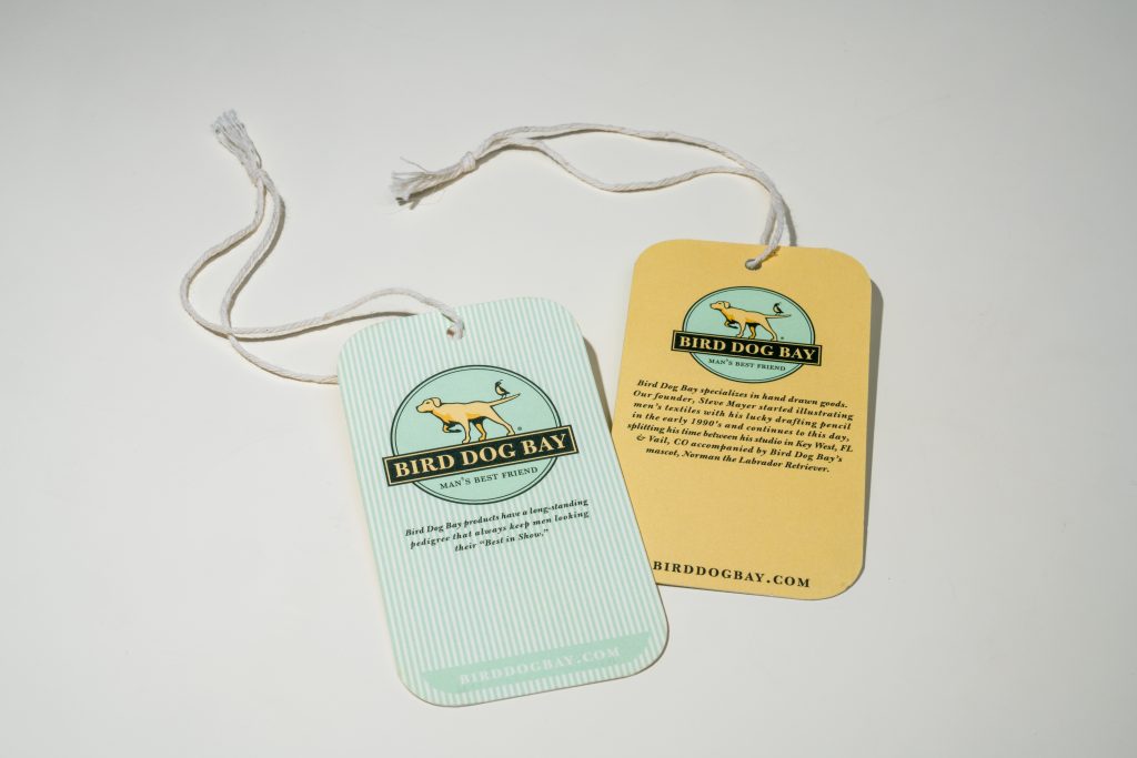 Colorful hang tags for the brand Bird Dog Ray featuring their logo in light blue and light yellow.