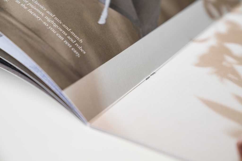 Close-up of the folded spine and staples in a booklet, showing the stitching detail behind saddle stitch booklet printing and why the method is known as saddle stitch binding.
