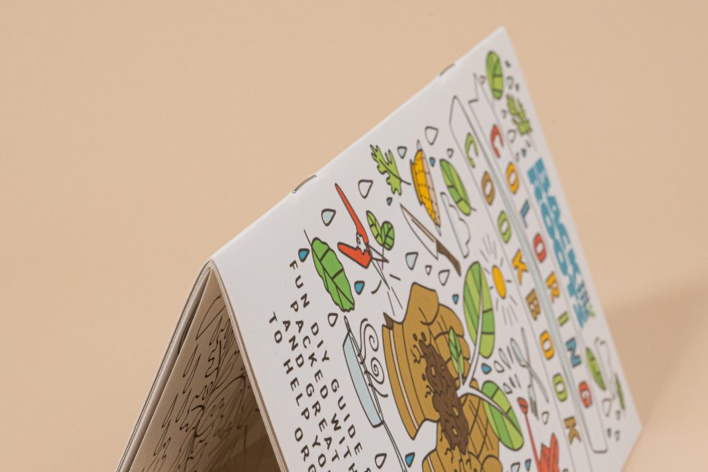 One open and one standing custom coloring book on a studio backdrop. A full-color cover with interior line art, great design for personalized coloring books.