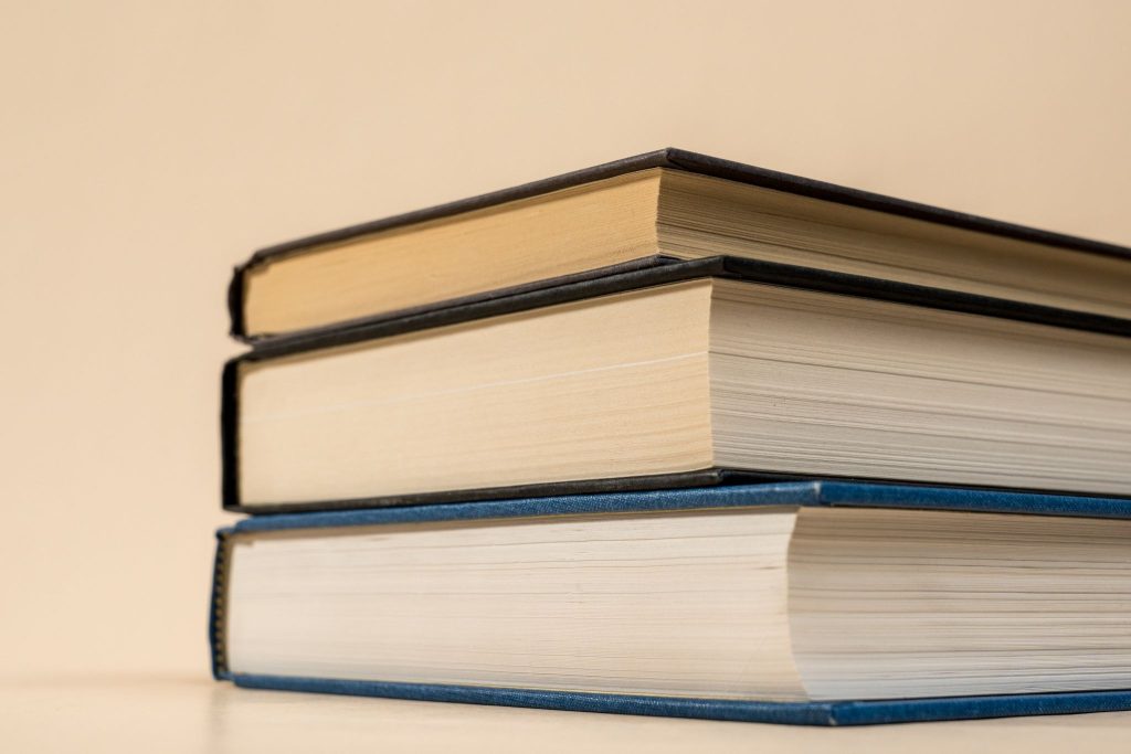 Stack of hardcover books with clothbound covers and visible board thickness