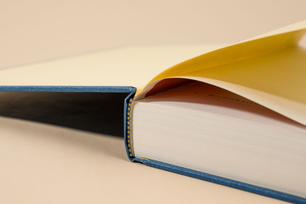 Close-up of hardcover book spine with dust jacket and sewn binding