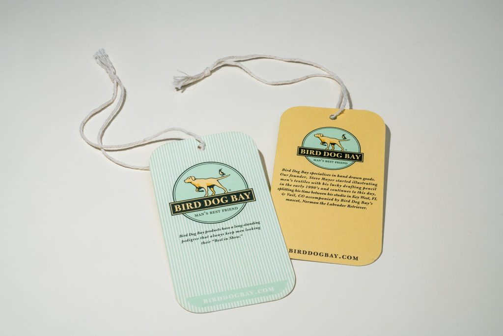 Two Bird Dog Bay branded hang tags with rounded corners and cotton string