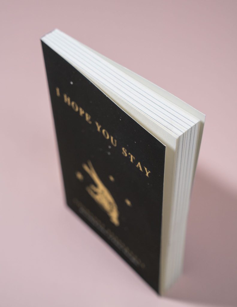 Top view of a paperback book with a matte black cover and gold foil title