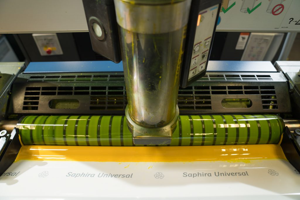 Vegetable-based sustainable ink being applied to paper on a printing press