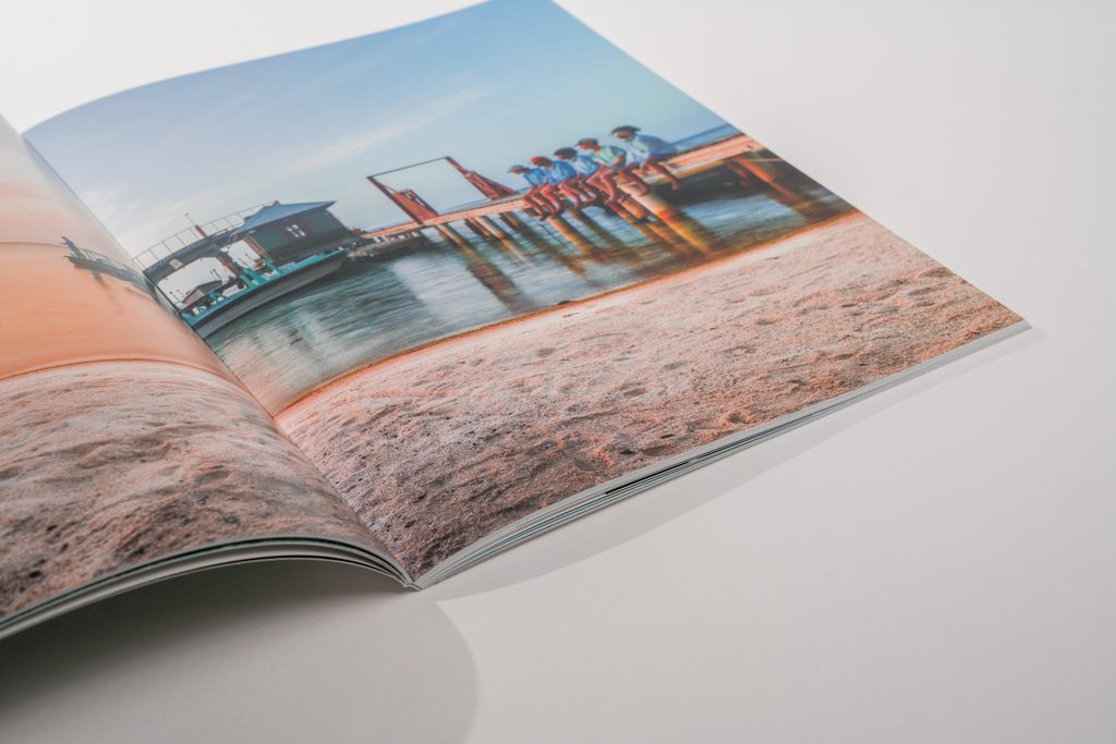 catalog spread open in the table with one page in midair