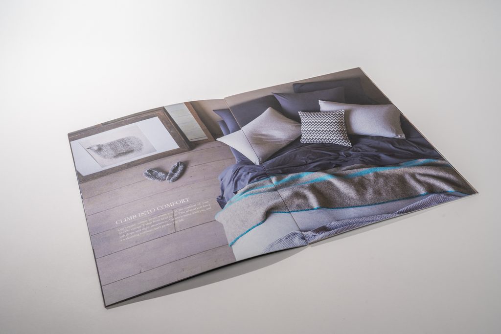 catalog spread open in the table with one page in midair