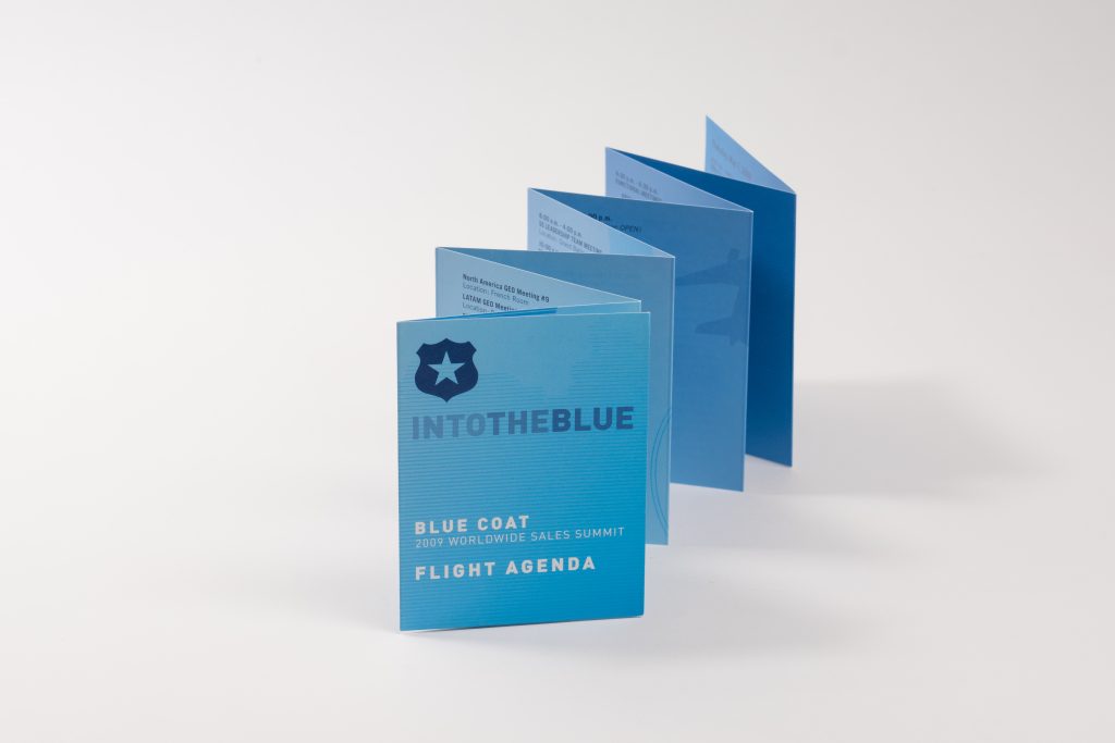 A blue accordion-fold agenda brochure standing upright on a white background.