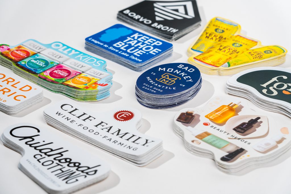adhesive labels next to a stack of individual sheet labels, side by side for comparison
