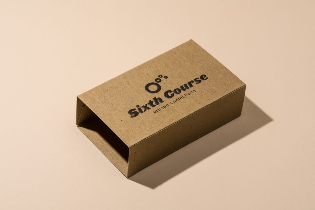 A rectangular kraft paper box sleeve resting on a plain, light beige background.