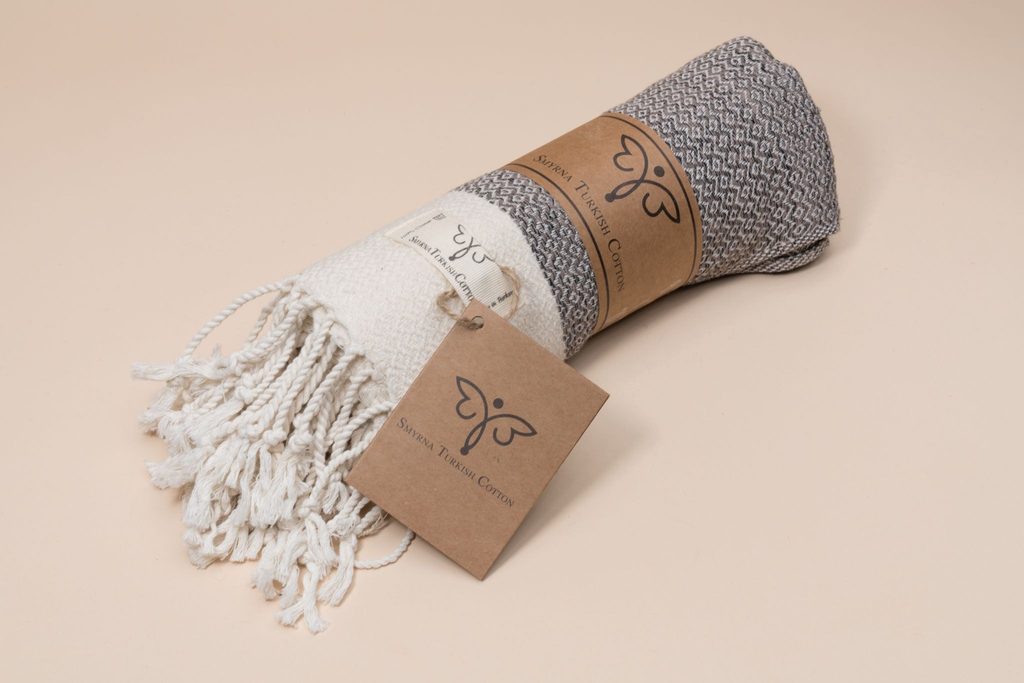 Image shows a blanket with a packaging sleeve and custom label made from sustainable materials.